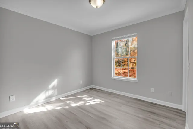 an empty room with a window and wooden floor