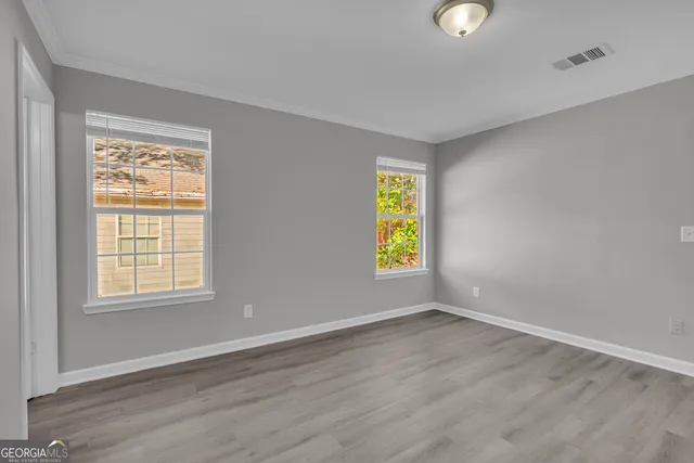a view of an empty room with wooden floor