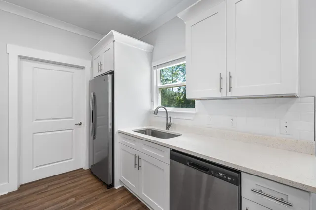 a kitchen with stainless steel appliances granite countertop white cabinets a microwave a sink and dishwasher