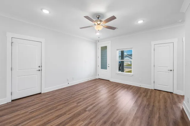 a large kitchen with a center island wooden floor stainless steel appliances and windows