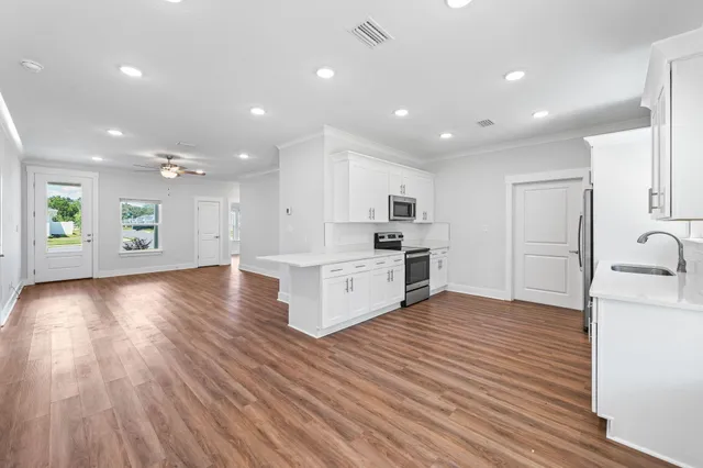 a kitchen with a sink cabinets and wooden floor