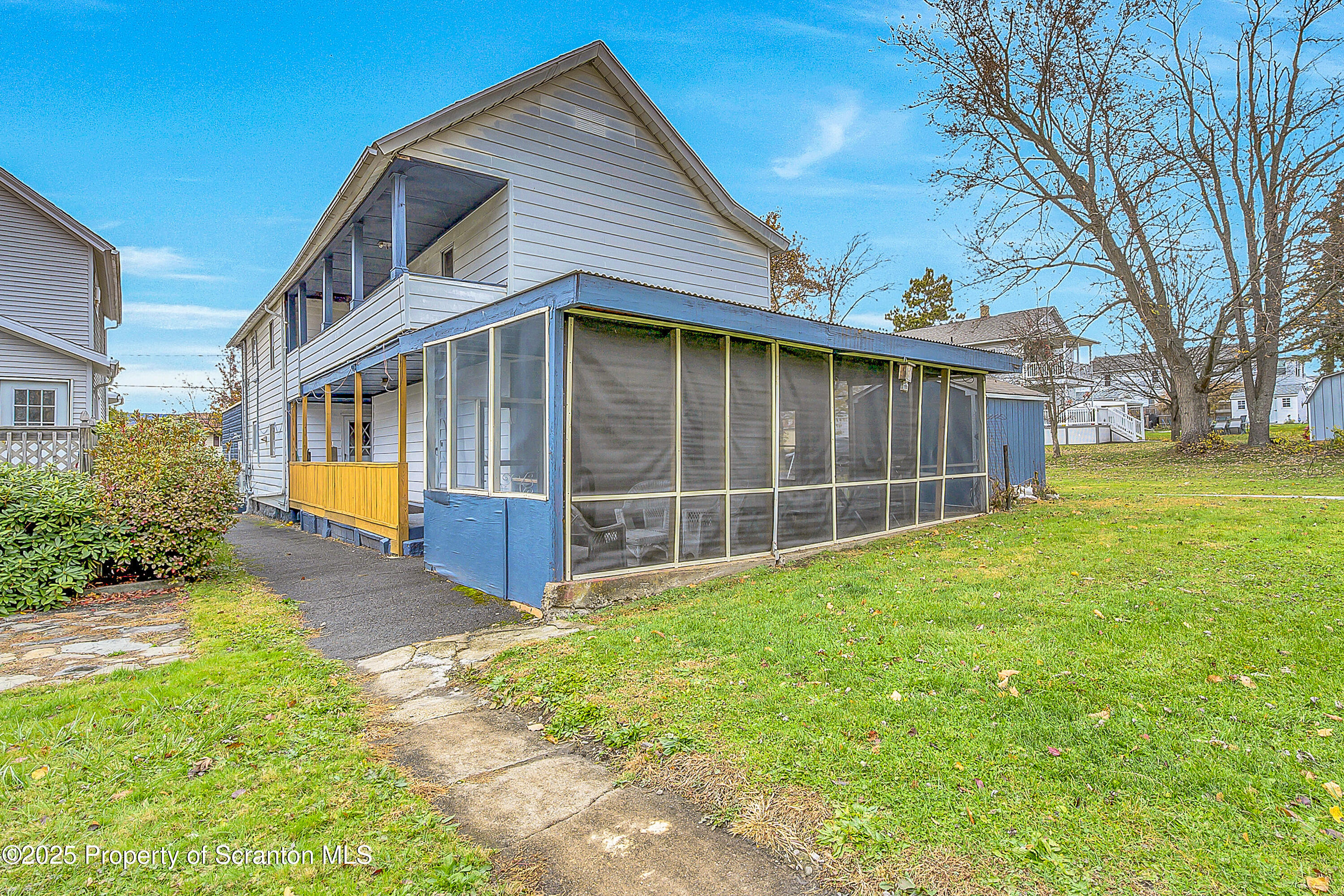 a view of a house with a yard and a large tree