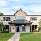 a front view of a house with a yard and trees