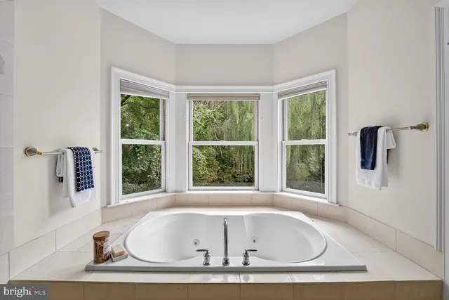 a white bath tub sitting in a bathroom next to a window