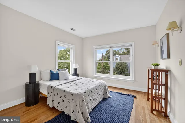 a bedroom with a large bed a chandelier and windows