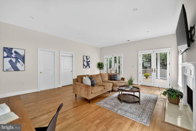 a living room with furniture flat screen tv and a large window
