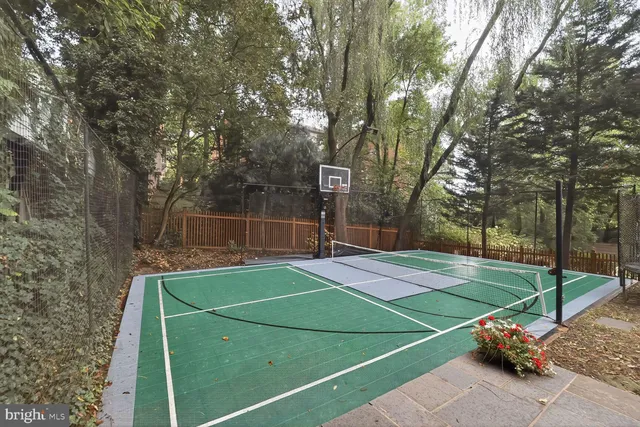 a view of a tennis ground with large trees