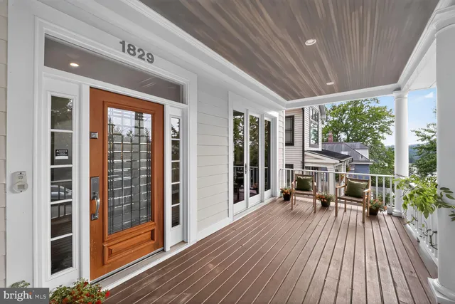 a view of living room and balcony with wooden floor
