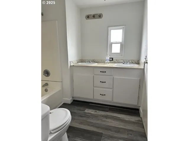 a bathroom with a granite countertop toilet sink and mirror
