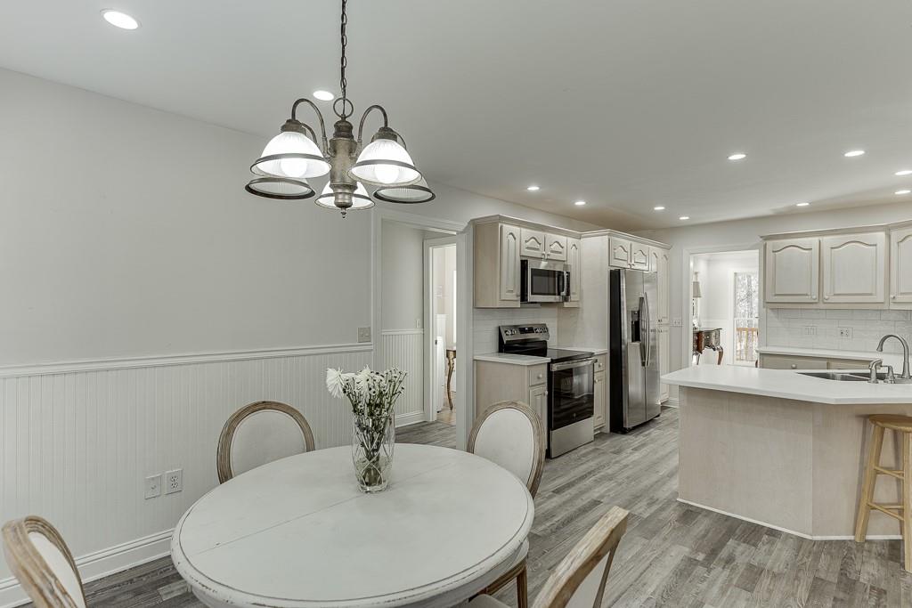 6360 Nix Road Dawsonville, GA 30534 - Photo 31 of 58 a kitchen with stainless steel appliances granite countertop a sink a stove a refrigerator with a dining table and chairs