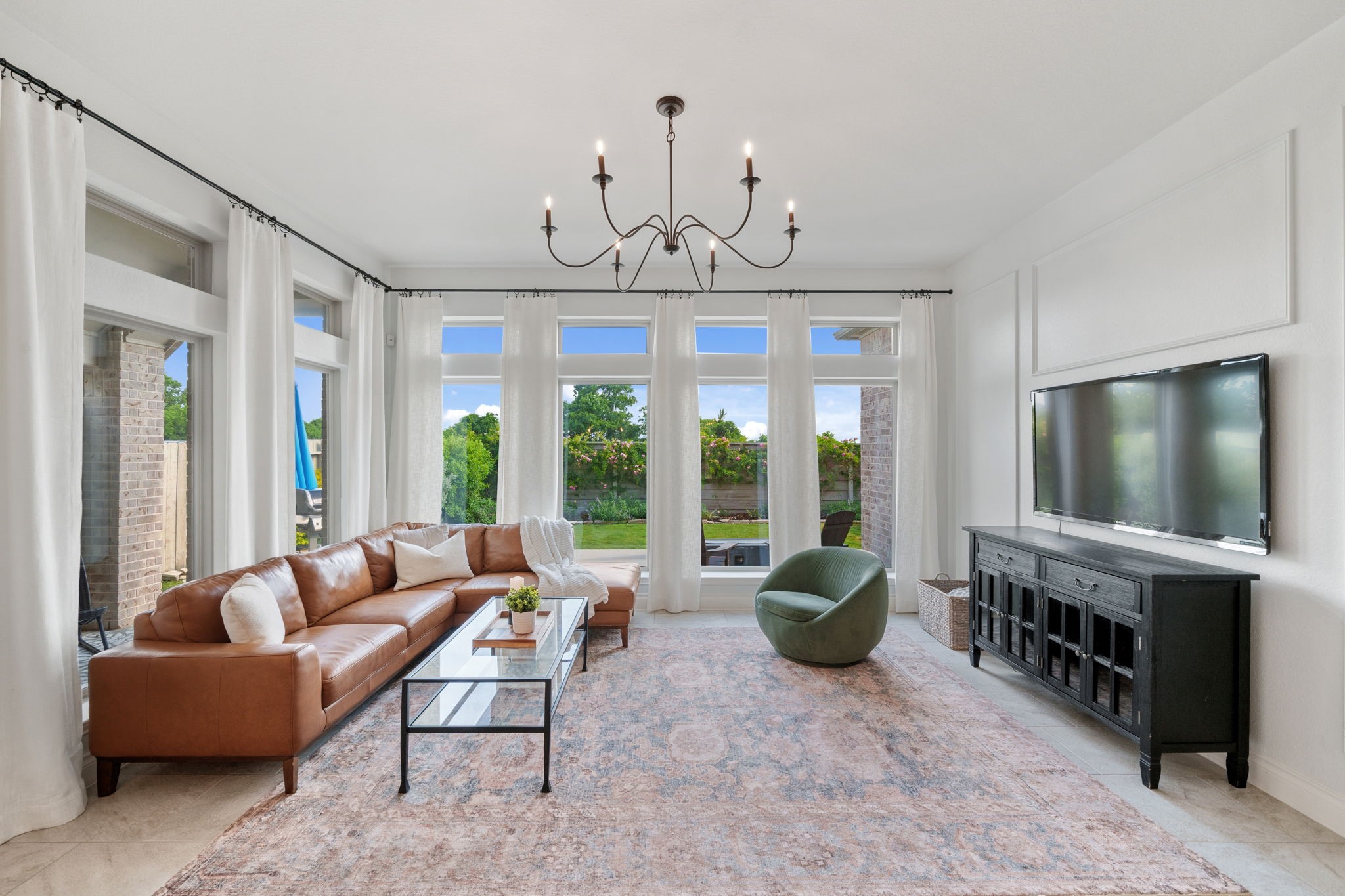 2119 Blackhawk Ridge Lane Manvel, TX 77578 - Photo 8 of 49 Bright and inviting living room bathed in natural light from a wall of oversized windows overlooking the private backyard. Features accent wall, elegant chandelier, and direct access to the covered patio.