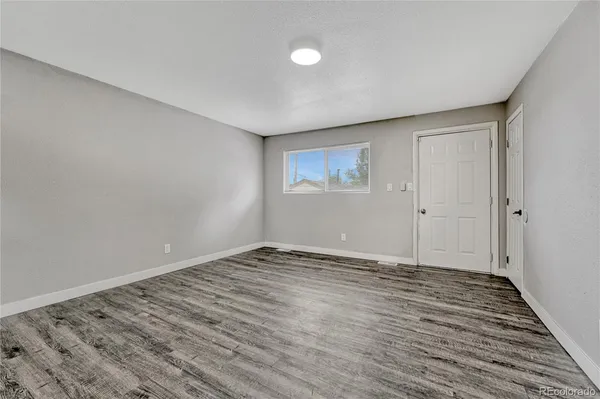 a view of an empty room with wooden floor