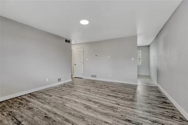 a view of an empty room and wooden floor