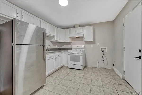 a kitchen with white cabinets and white appliances