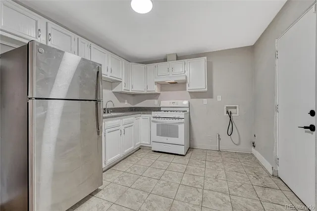 a kitchen with white cabinets and white appliances