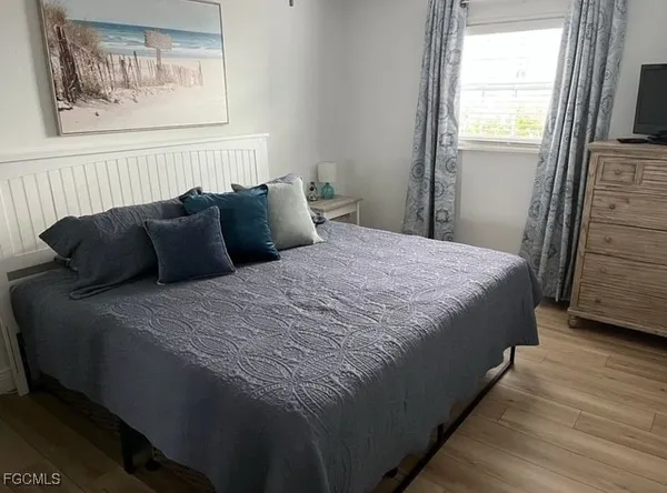 a bedroom with bed and wooden floor