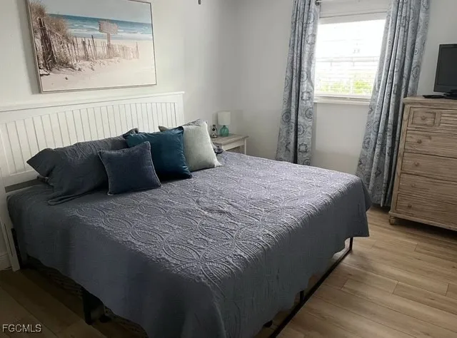 a bedroom with bed and wooden floor