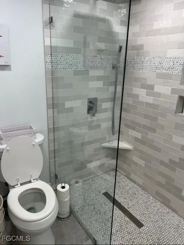 a bathroom with a toilet and a shower