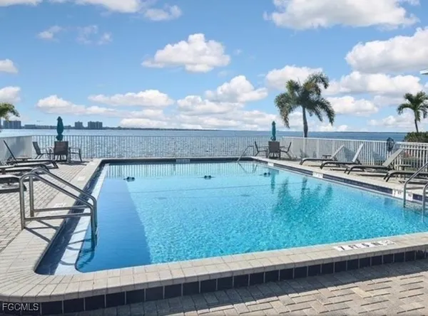 a view of a swimming pool with lawn chairs