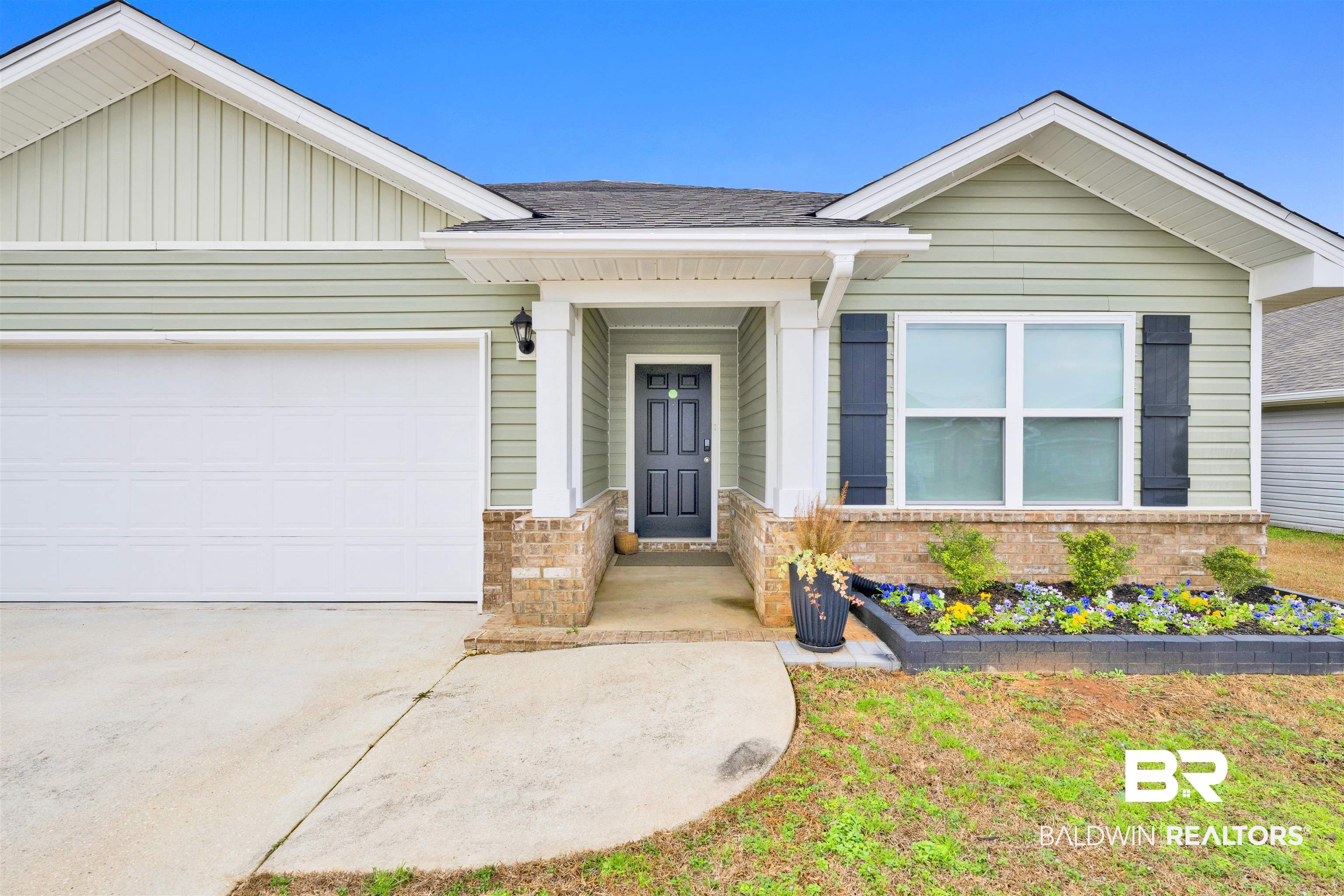10763 Paget Drive North Mobile, AL 36608 - Photo 2 of 24 Ranch-style house with a garage, board and batten siding, driveway, a shingled roof, and brick siding