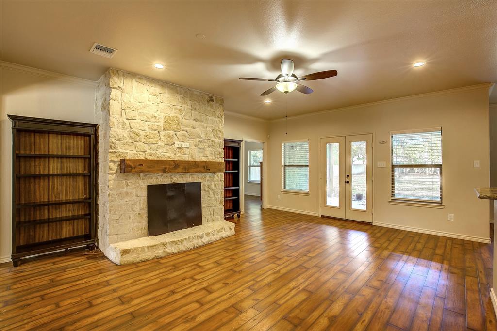 2617 Kirby Road Rowlett, TX 75088 - Photo 6 of 39 Unfurnished living room with ornamental molding, ceiling fan, a fireplace, dark wood-style floors, and plenty of natural light