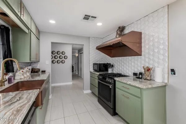 a kitchen with stainless steel appliances kitchen island granite countertop a refrigerator and a sink