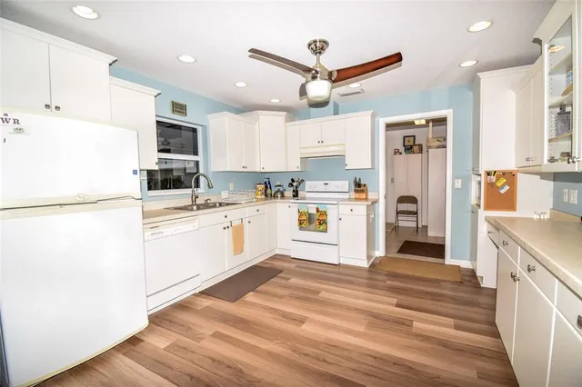 a living room with furniture a flat screen tv and a wooden floor