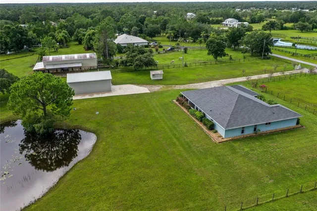 an aerial view of a house with a yard basket ball court and outdoor seating