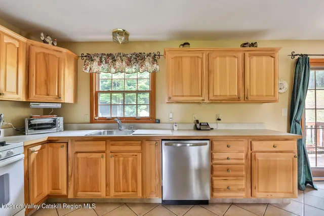 a kitchen with stainless steel appliances granite countertop wooden cabinets a sink and a window