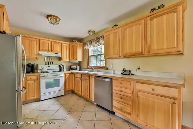 a kitchen with granite countertop cabinets stainless steel appliances a sink and a window