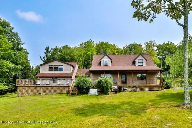 a front view of a house with a garden and swimming pool
