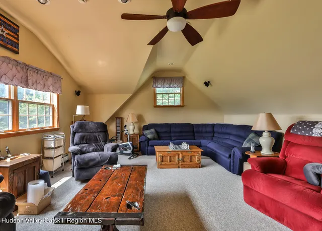 a living room with furniture ceiling fan and a window