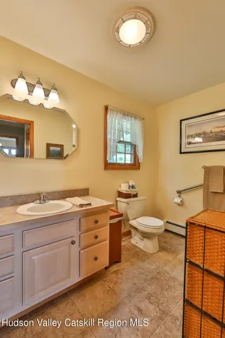 a bathroom with a toilet sink vanity granite and mirror