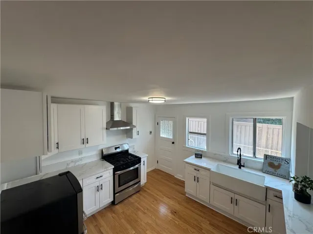 a large white kitchen with cabinets stove and sink