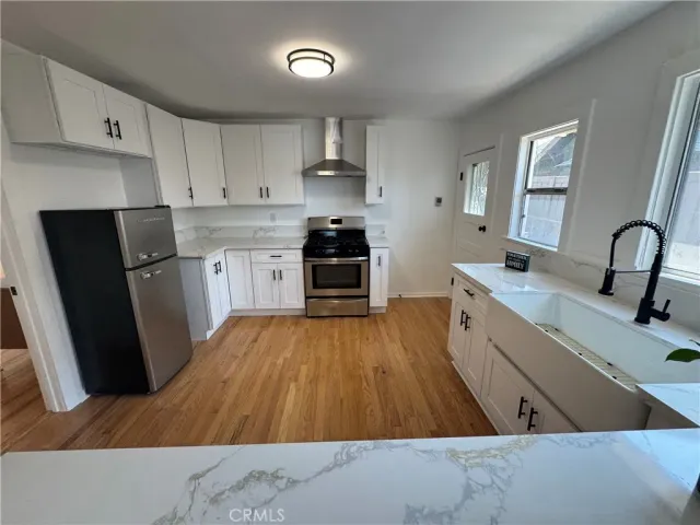a kitchen with wooden floors and appliances