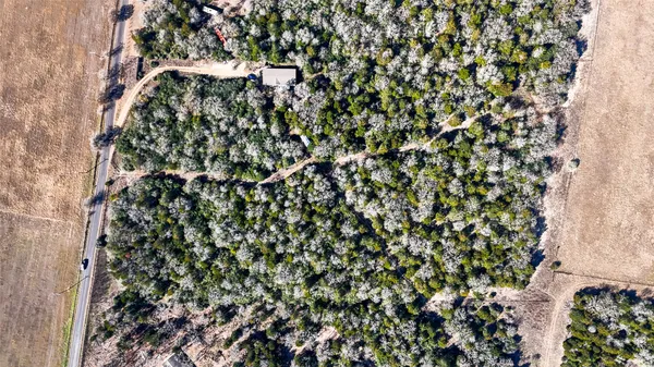an aerial view of a residential houses covered with trees