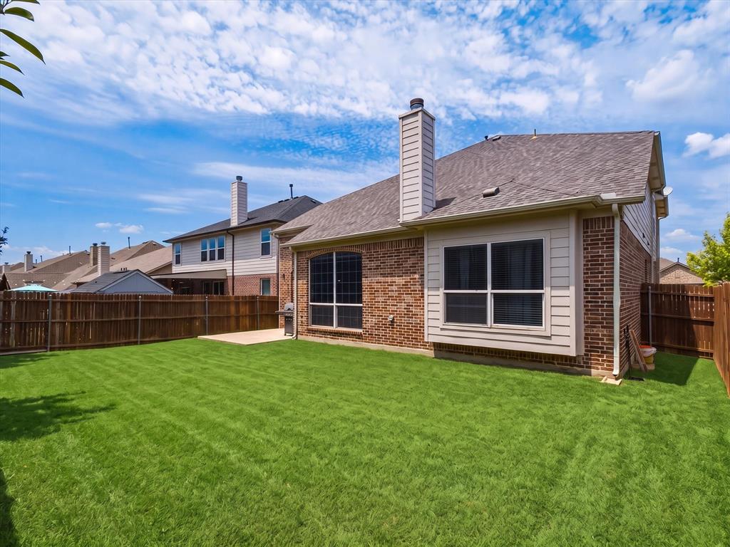 2364 Ranchview Drive Little Elm, TX 75068 - Photo 32 of 33 Expansive green lawn, wood fence perimeter, brick exterior, bay window, and a patio area