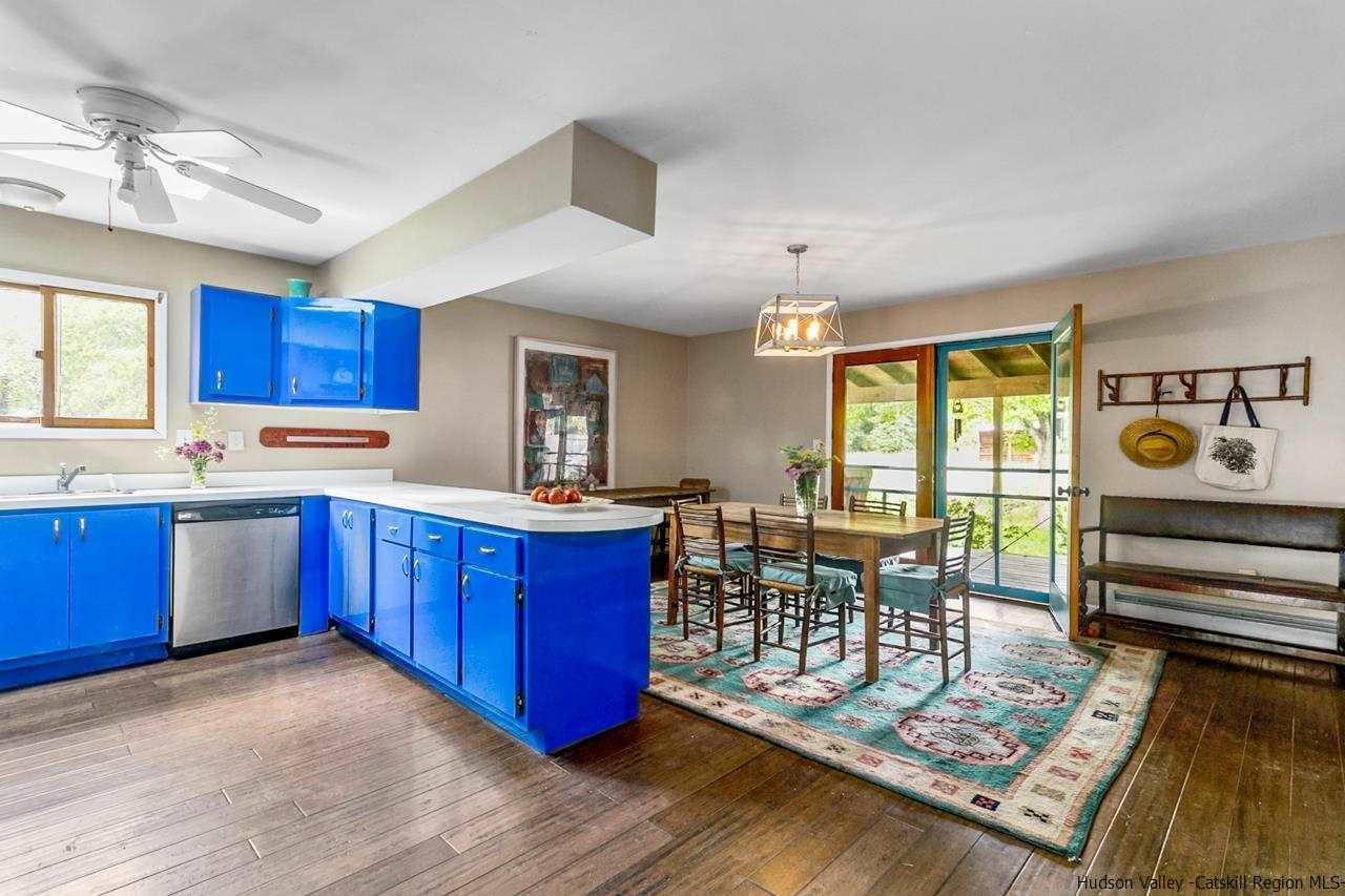 665 Scotchtown Collabar Road Middletown, NY 10941 - Photo 7 of 22 a kitchen with stainless steel appliances granite countertop a stove top oven a dining table and chairs with wooden floor