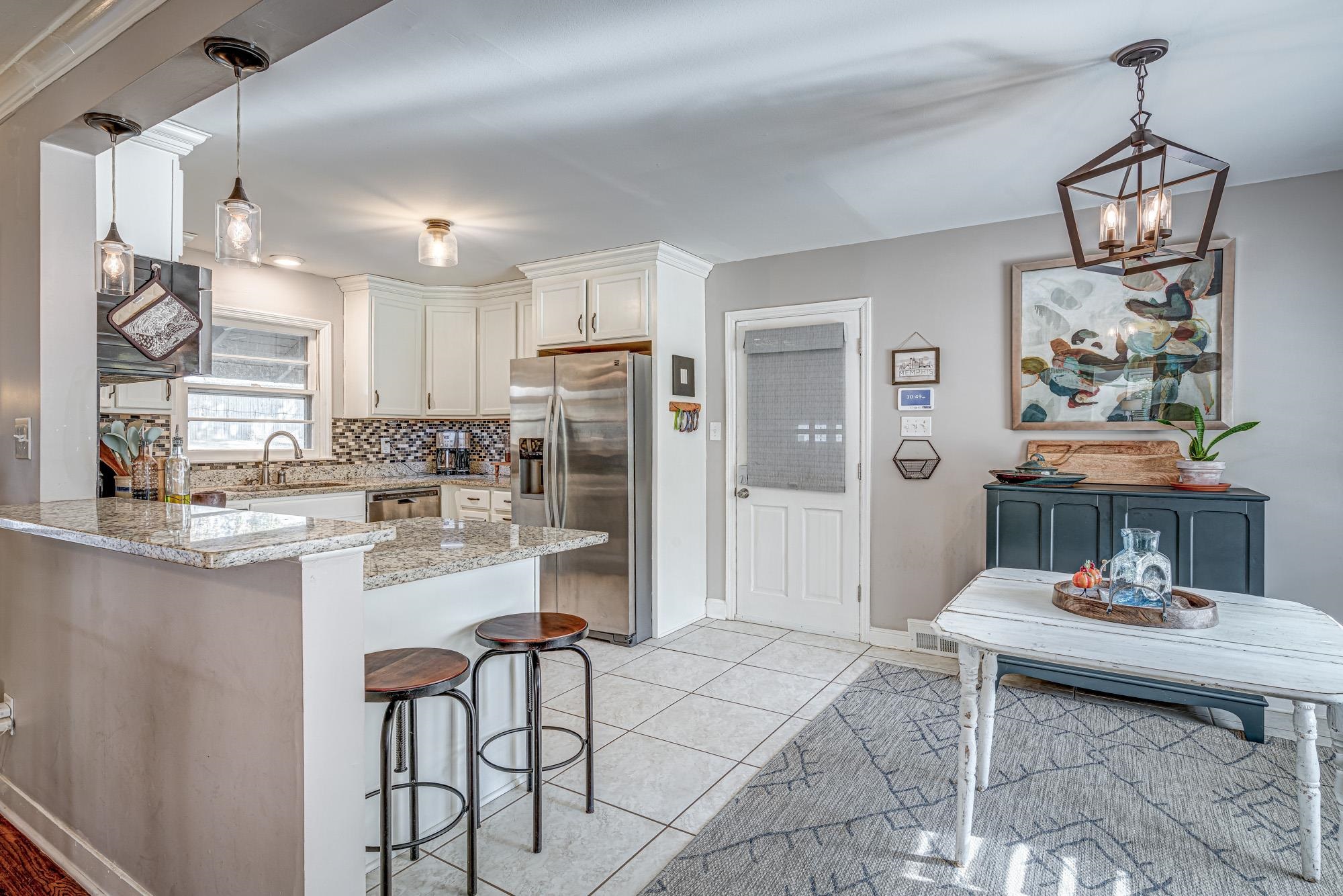 5362 Sea Isle Road Memphis, TN 38119 - Photo 9 of 21 a kitchen with stainless steel appliances kitchen island granite countertop a refrigerator a stove and white cabinets with wooden floor