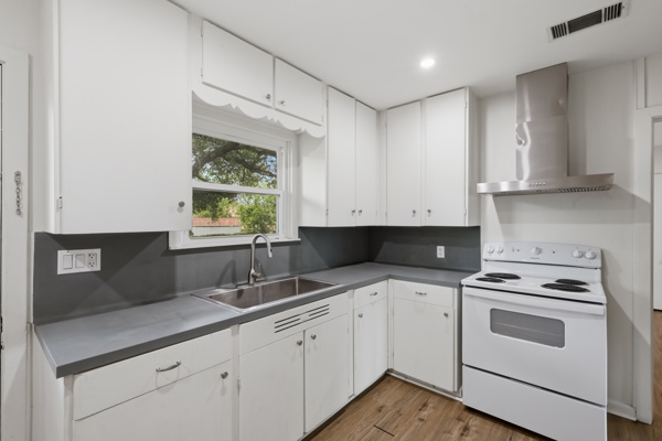 1608 Burt Street Bryan, TX 77802 - Photo 7 of 16 a kitchen with granite countertop white cabinets white appliances and a sink