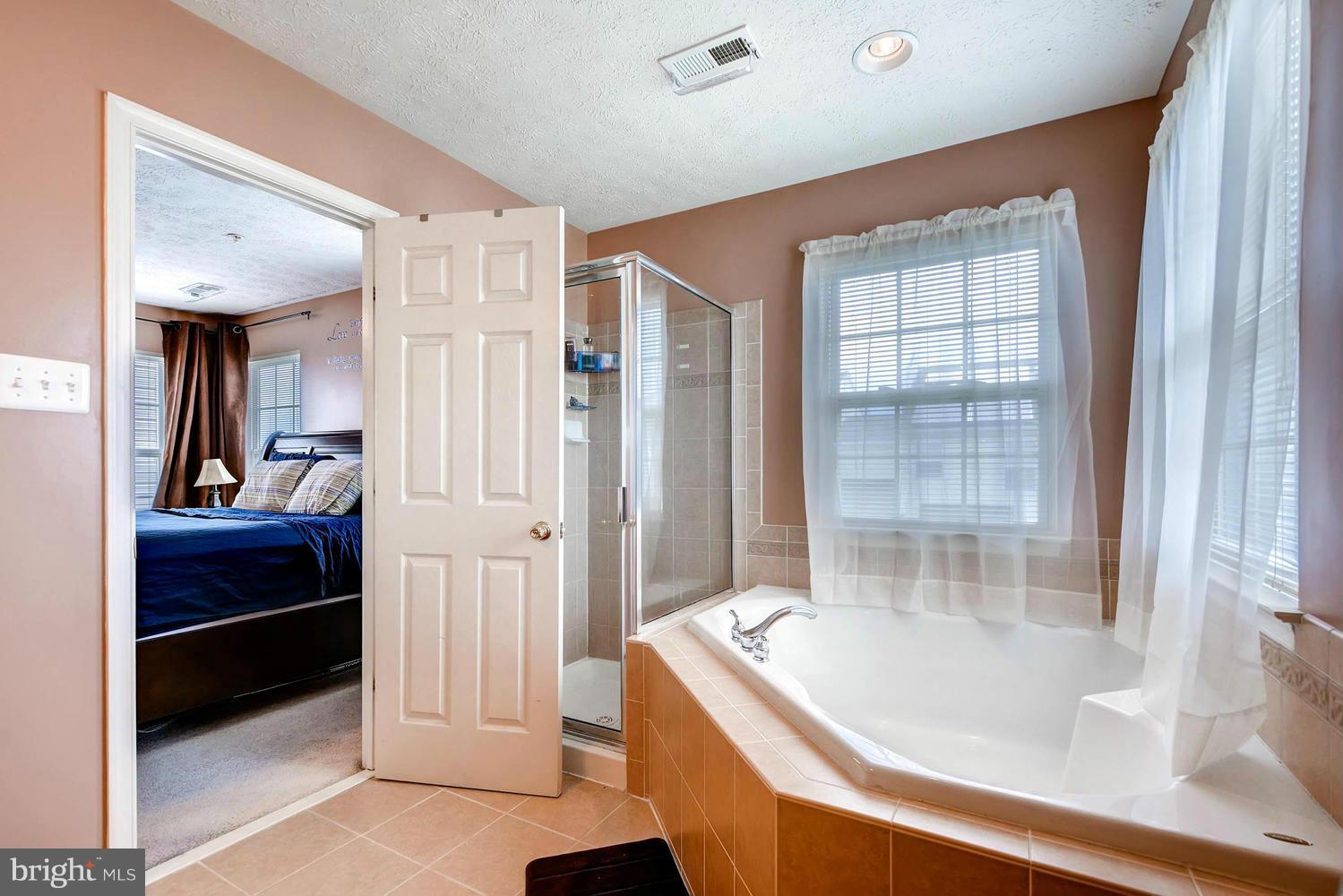 9714 Langley Road Baltimore, MD 21220 - Photo 17 of 27 a bathroom with a tub and shower