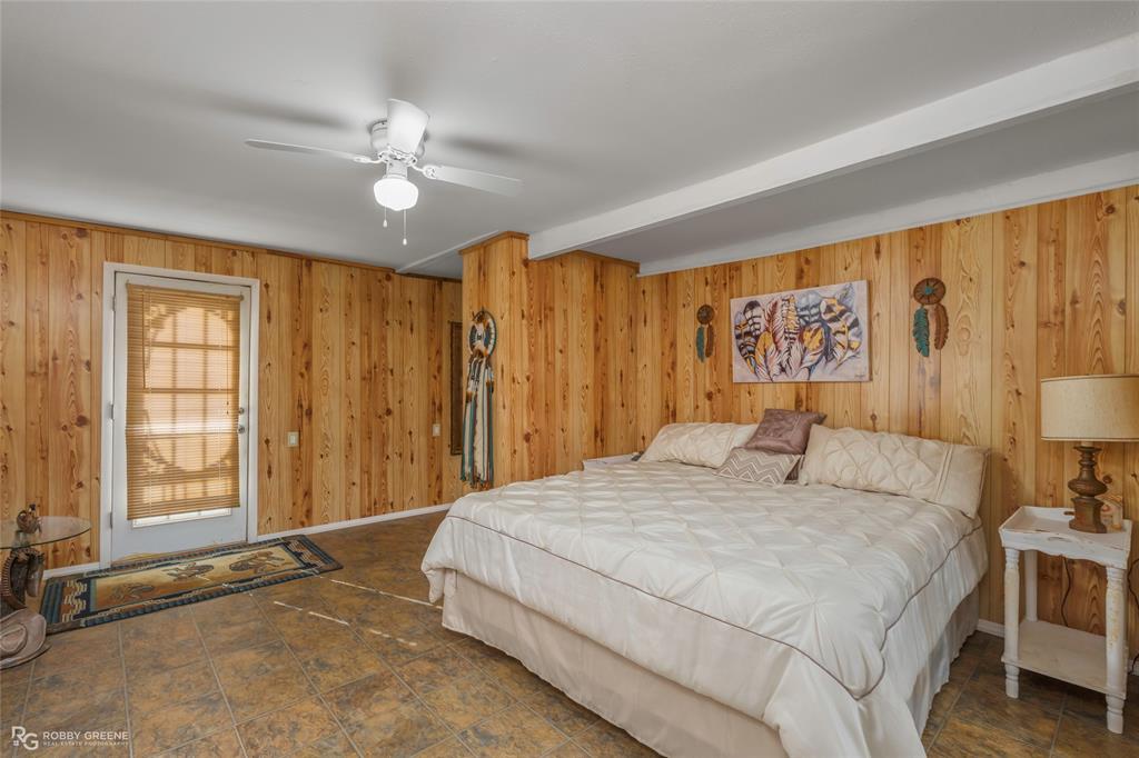 121 Willow Street Heflin, LA 71039 - Photo 24 of 39 a bedroom with a large bed and a chandelier