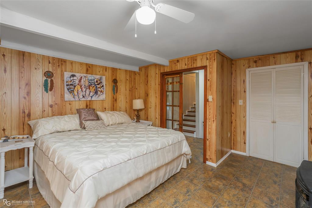121 Willow Street Heflin, LA 71039 - Photo 25 of 39 a bedroom with a large bed and a chandelier