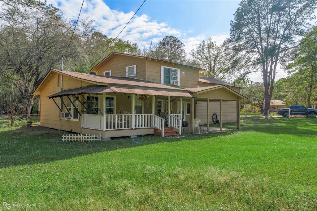 121 Willow Street Heflin, LA 71039 - Photo 8 of 39 a view of a house with a yard and a garden