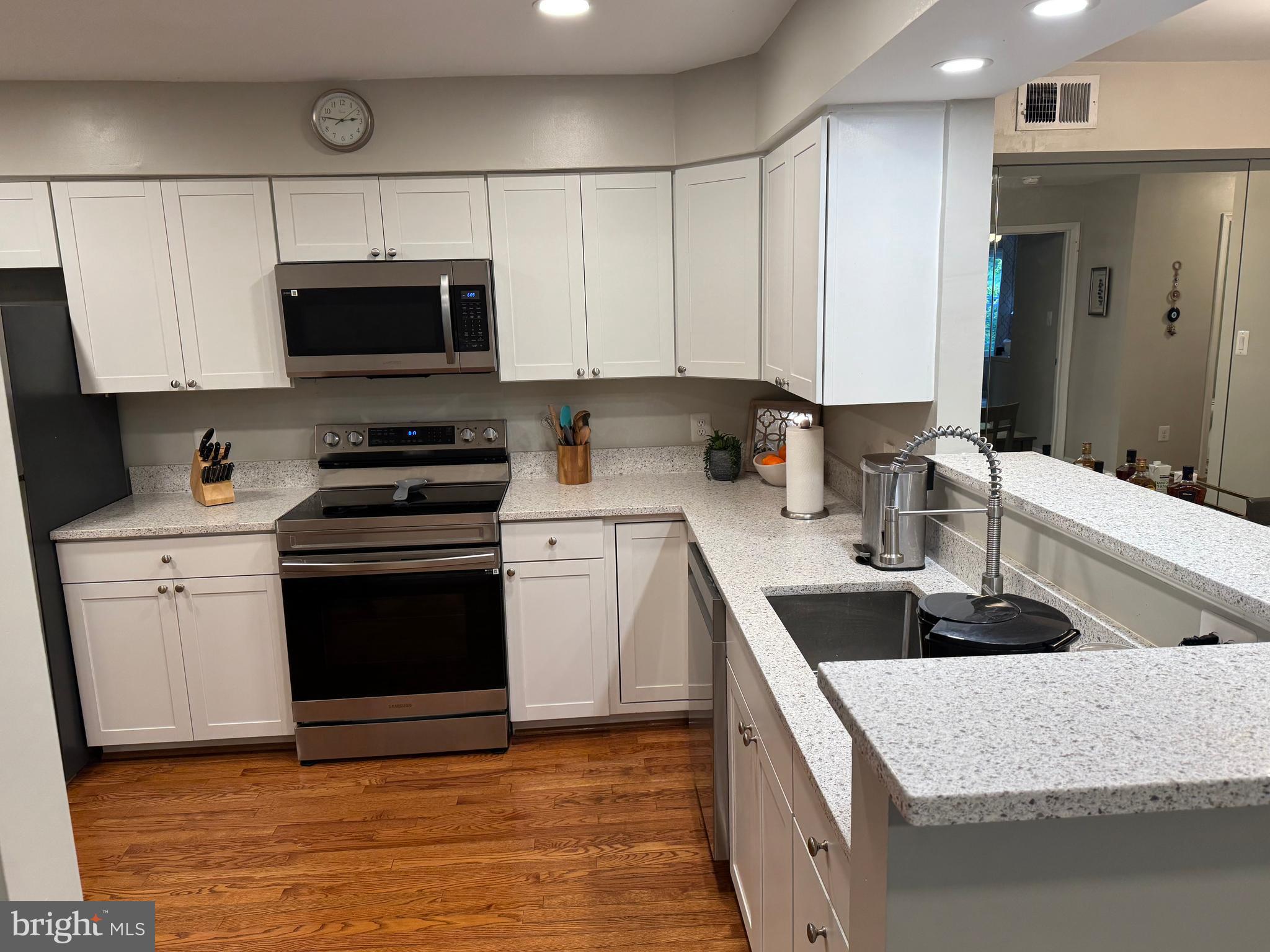 11709 Karbon Hill Court, Unit I Reston, VA 20191 - Photo 12 of 38 a kitchen with stainless steel appliances granite countertop a sink stove and refrigerator
