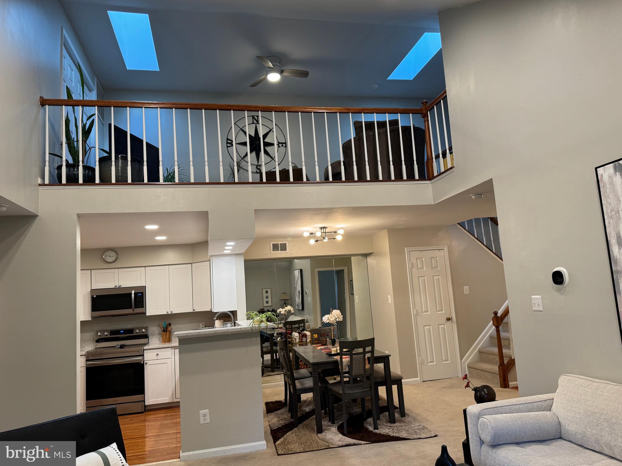 11709 Karbon Hill Court, Unit I Reston, VA 20191 - Photo 18 of 38 a kitchen with stainless steel appliances kitchen island granite countertop a refrigerator a stove a sink and a dining table with wooden floor