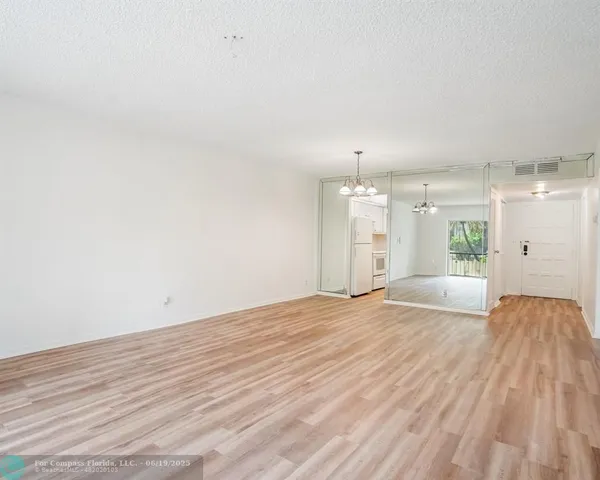 a view of an empty room with a kitchen