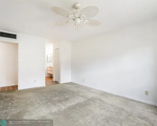 a view of a big room with chandelier fan