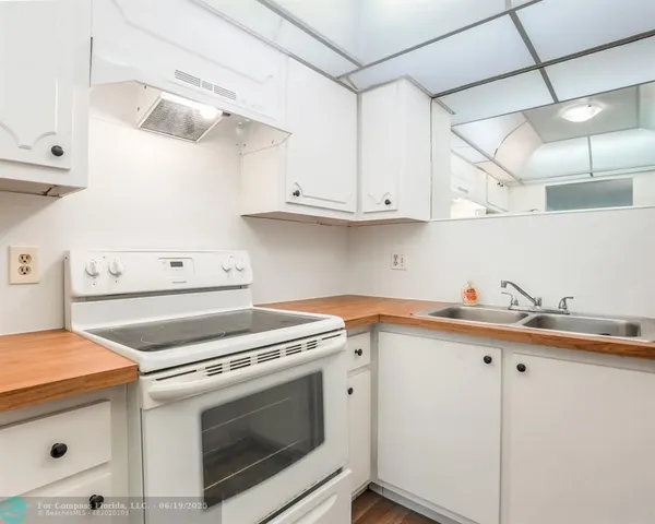 a kitchen with cabinets appliances and a sink