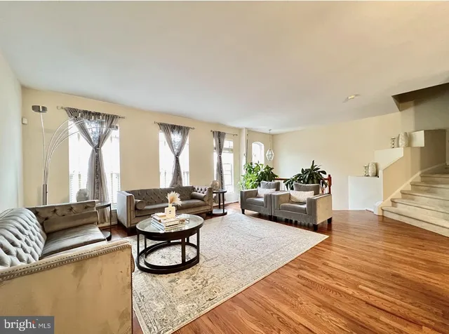 a living room with furniture and a wooden floor